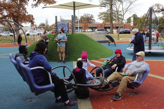 Young and old enjoy the newly renovated Woodland Veterans Park, including this four-seat teeter-totter, during the park’s re-opening on Nov. 11.