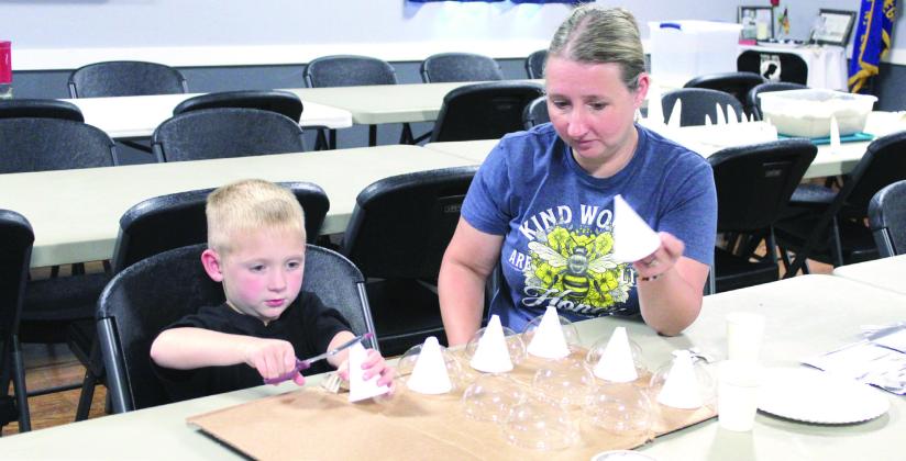 Lincoln Nickell, 5, of McLoud, and his mom, Tonya Nickell, work together on a protective breast plate that would hold up to a hit from a Stegosaurus tail.