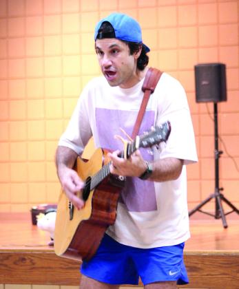 Syman Hajjar, of Hot Toast Music Company, sings and plays guitar to his signature song, 'Hot Toast!' on July 30.