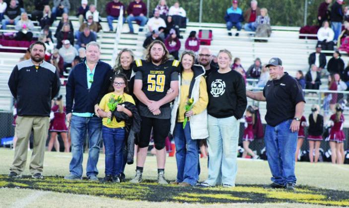 Tecumseh Head Football Coach Ty Bullock, far left, participates in Senior Night ceremonies with Julian Borromeo and his family, including Borromeo’s grandfather and THS principal Randy Dilbeck, far right, on Nov. 3.