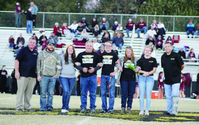Tecumseh Band Director John Outon, far left, participates in Senior Night ceremonies with senior drum major Jessy Thoma, fifth from left, and his family, including his sister band member Laycee Thoma, seventh from left, on Nov. 3.