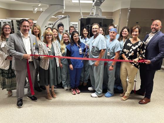 SSM Health Saints Heart Cardiologists Isma Javed, MD, and Troy Norred, MD are surrounded by hospital administrators and Cardiac Cath Lab staff as they prepare to cut the ribbon on the new Cath Lab. Photo provided