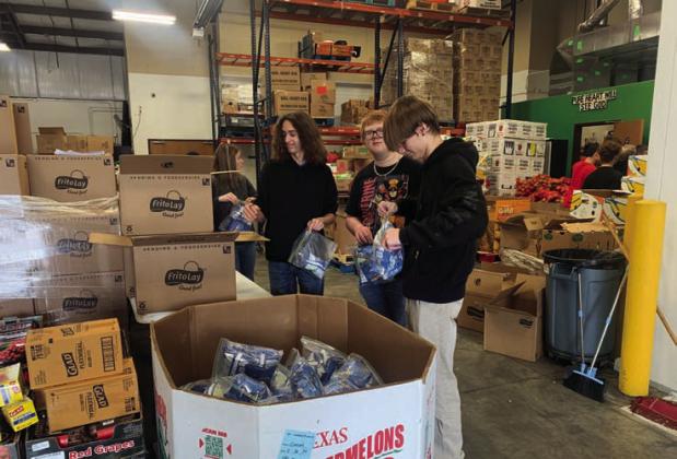 Dale FFA students repackage bags of chips at the Community Market of Pottawatomie County. Dale FFA placed second in the First United Bank Harvesting Impact contest in December 2024. North Rock Creek FFA placed first, and Shawnee High School FFA came in third. Photo provided by Jon Golliver.