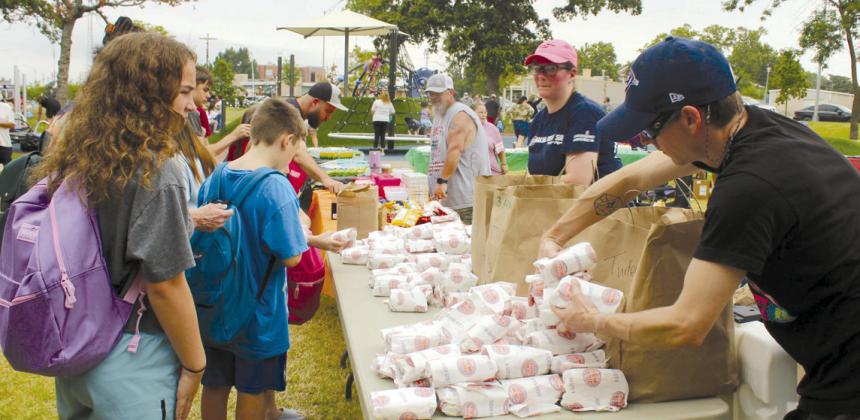 Jersey Mike's Subs owner Dani Mirich watches as Jason Trexler stacks up the sandwiches to give away during the Second Annual Hug-a-thon on Aug. 2 at Woodland Veterans Park. The restaurant donated $2,000 in sandwiches, and Dunbar Heights Community Group added another $600 worth.