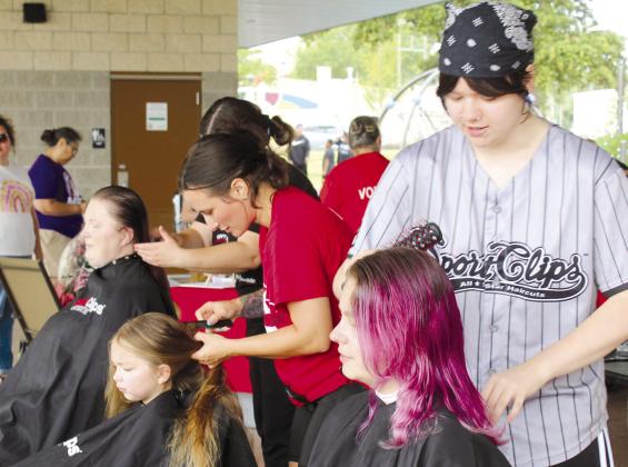 Amanda O'Dell, Makayla O'Dell, 7, and Jessika O'Dell, all of Shawnee, get their hair cut for free by Sport Clips stylists Nicole Lawless, Brittany Burden and Libertee De-sordi, respectively.
