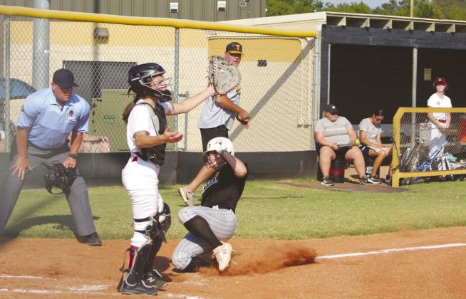 Tecumseh junior Katie Overstreet slides into home as the Holland Hall catcher waits for the throw, and Head Fastpitch Coach Chad Trahan and the umpire watch. Overstreet hit her home run in the second inning of the Aug. 22 game. The Lady Savages won, 11-0. Countywide &amp; Sun/Natasha Dunagan