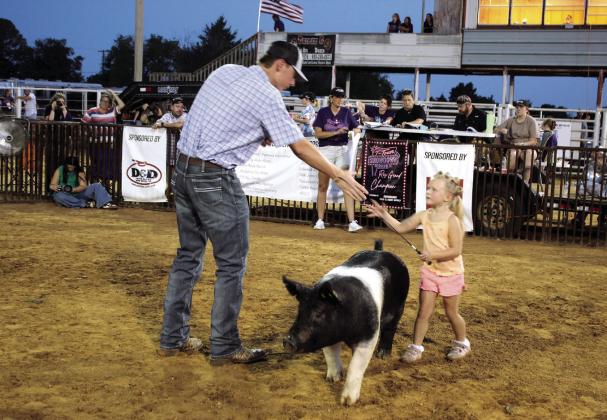 Tecumseh 4-H member Tatum Davis shakes hands with livestock judge Garret Wellden after showing her Hampshire hog during the T-Town Showdown on Aug. 22 at the Tecumseh Roundup Club. Photos by Natasha Dunagan, Countywide &amp;amp; Sun
