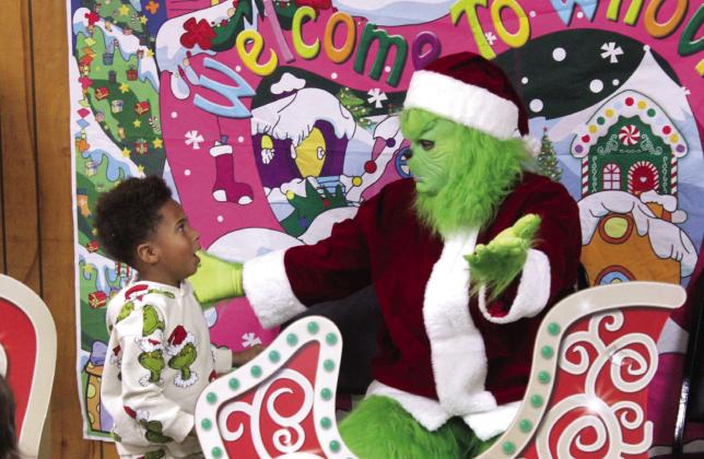 Trevion Mucker, Jr., 4, of Shawnee, is surprised after the Grinch gave him a hug during the First Annual Grinch-Fast, held at the Veterans of Foreign Wars in Shawnee on Nov. 29. This was a fundraiser for the Pott. County Giving Project, which has 618 children and adults with disabilities on their Christmas list this year. Natasha Dunagan, Countywide &amp; Sun
