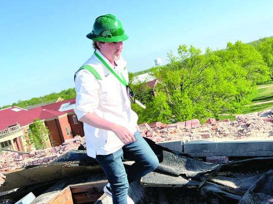 Oklahoma Baptist University President Dr. Heath A. Thomas inspects the roof damage of Shawnee Hall following the April 19, 2023, tornado. Thomas said every building on the campus was damaged. Photo provided by OBU