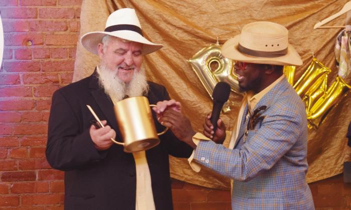 Emcee for the evening, Jamelle Payne, gifted a watering can to Vortex co-owner, David Thomas in honor of him 'watering the community' by coming up with the idea and hosting the fundraising event for the benefit of Shawnee.