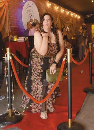 Becky Webb blows a kiss to the camera as she walks the red carpet as a participant in the Rags 2 Runway fashion show.