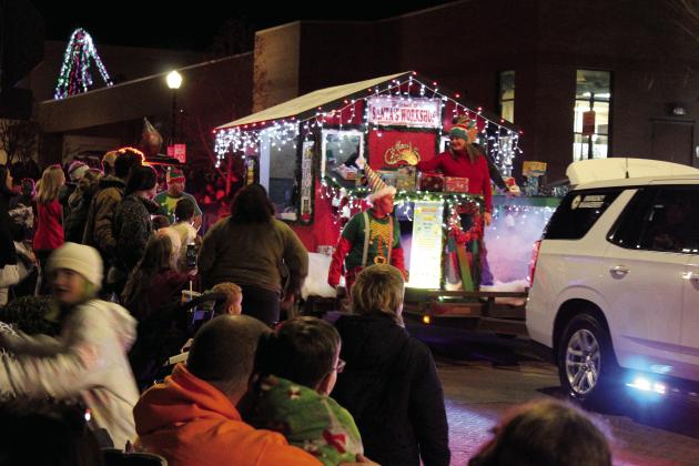 Volunteers and employees of Emergency Management of Pottawatomie County ride on or walk beside their Santa’s Workshop float in the Shawnee Christmas Parade on Dec. 8. Countywide &amp; Sun/Natasha Dunagan
