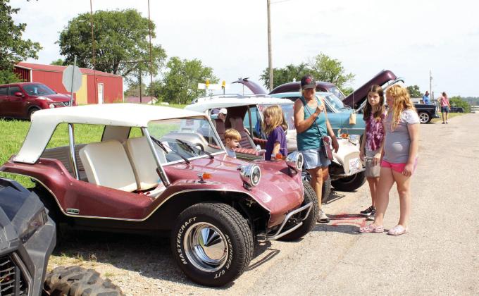 Theodore McCracken, 4; Lily McCracken, 8; Tammy Dodgion; Kaylee McCracken, 12; and Gemma Dodgion, 7, examine a 1966 VW Dune Buggy owned by Bobby and Patty Jones of Wanette during the car show held in Macomb on June 23.