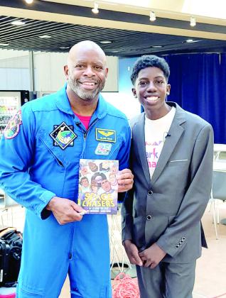 Leland Melvin poses with Shawnee Middle School student, Isaiah Lightsey, while showing off his book "Space Chasers," after sitting down for a personal interview. Photo Provided