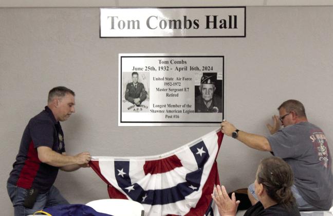 American Legion Post #16 Commander Keith DiPatri, left, and Post Adjutant Richard Filbert unveil the new sign in memory of Air Force veteran Tom Combs during the rededication of their bingo hall on March 29. Natasha Dunagan, Countywide &amp; Sun
