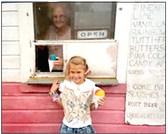 Snow Boy Snow Cones owner Virginia Eddings serves snow cones to a little girl. Eddings owned the stand from 1962 until 2002. The stand has existed at 722 S. Beard in Shawnee since 1952. Photo provided.
