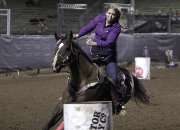 Josey Milburn of Asher is careful to steer around the third barrel in the barrel racing event of the International Finals Youth Rodeo on the evening of July 13.