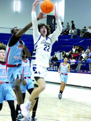 Shawnee freshman Edan Litherland is fouled as he goes up for a shot during the Dec. 12 game against Western Heights. The Wolves won, 86-58, and the Lady Wolves won, as well, 60-8, earlier that night.