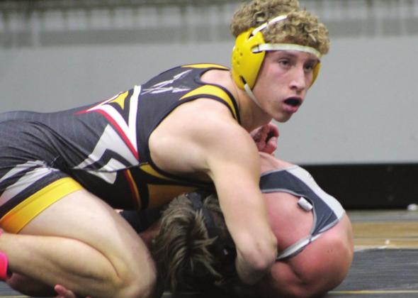 Tecumseh’s Jace Frazier, in the 160-pound class, looks up for instructions from his coach during the dual meet against Perkins-Tryon. Frazier won by a fall.