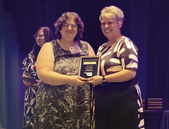 Natasha Dunagan, left, receives a first place plaque from OPA President Sheila Gay for her business article. Countywide &amp; Sun/Julie Talton
