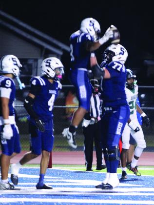 Shawnee senior Kaden Bramlage lifts fellow senior Tate McClendon in celebration of McClendon's touchdown in the second quarter of the Oct. 23 homecoming game. The game was called at halftime due to lightning, but the Wolves won against Tulsa's Edison Prep, 38-0. Athletic Director Dax Leone said both coaches agreed.