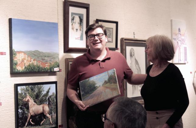 Michael Williams, of Bethel, chooses a painting by Lucy Ketch, right, at the Mabee-Gerrer Museum of Art "Off the Wall" event on April 25. According to Director Dane Pollei, 60 artists donated 129 works of art to the 16th annual fundraiser. Natasha Dunagan, Countywide &amp; Sun