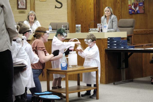 Shawnee Early Childhood Center Fab Lab Teacher Hannah Jett supervises a science experiment involving dry ice bubbles during the May 1 Shawnee Board of Education meeting. Indigo Bass and Benjamin Norwood are demonstrating the experiment, as Board Clerk April Stobbe and outgoing Superintendent Dr. April Grace react.