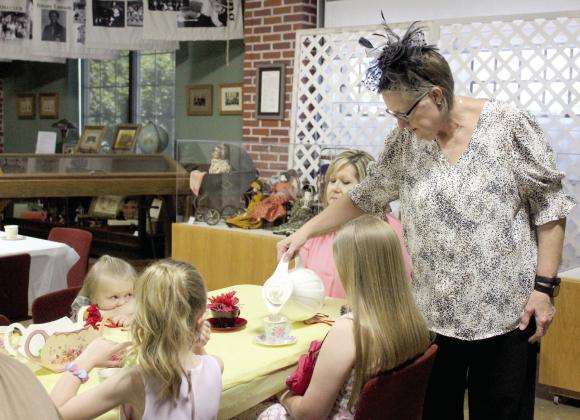 Lisa Lempges serves drinks during the First Annual McLoud Historical Society Tea Party, held at the museum on May 3. About 22 people and five historical society members attended. Natasha Dunagan, Countywide &amp; Sun