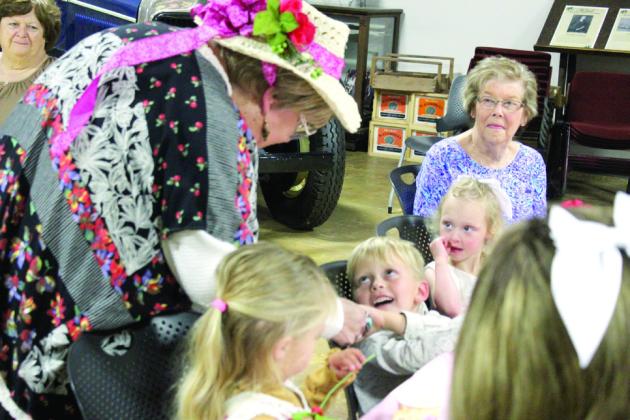 Retired counselor Linda Crosthwait shakes hands with Augustus Gentry, 5, as Jessie Gentry, 3, left, Melody Brackett, 3, and their great-grandmother Janet Brackett watch. Crosthwait spoke to everyone about good manners. Natasha Dunagan, Countywide &amp; Sun