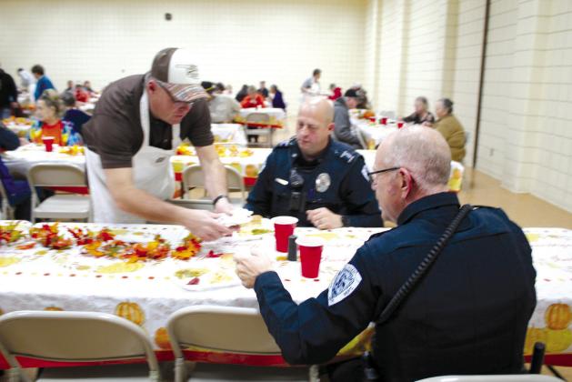 Tecumseh Police Chief J.R. Kidney serves Tecumseh patrolmen Aaron McCormick and J.D. Sanders during the 17th Annual Tecumseh Family Thanksgiving Dinner on Nov. 24. Kidney and his family have volunteered at the event for more than 10 years. Countywide &amp;amp; Sun/Natasha Dunagan