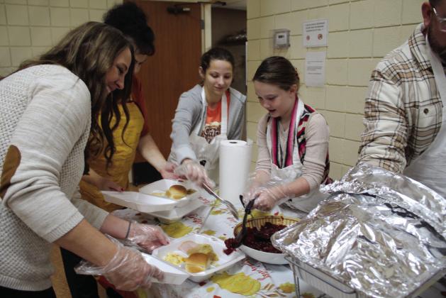 Volunteers Jessica Utter, Suzanne Gilbert, Kerrigan Kerbs and Taycie Baker work together to fill to-go and dine-in orders during the Tecumseh Family Thanksgiving Dinner, held at the Tecumseh City Hall Auditorium on Nov. 24. About 997 people attended or picked up meals at the event.