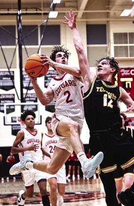 Tecumseh’s Kohen Warden tries to block the shot as North Rock Creek’s David King leaps to the basket. Photo courtesy of Gowin Photography