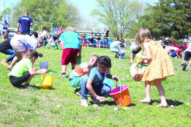 Seven and eight-year-olds gather plastic eggs during the Tecumseh EGGsperience and Block Party.