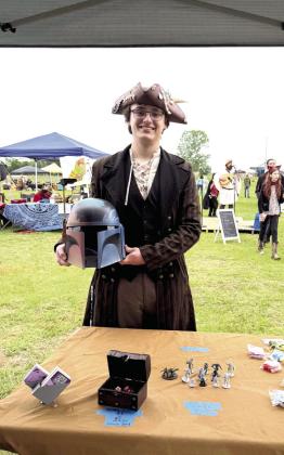 Pictured right, Shawnee's Lane Cowan poses with a helmet he made and sold at the Fifth Annual Secret Garden Medieval and Fantasy Faire held behind Shawnee Mall on April 25-26. Cowan says he will gladly participate again next time and bring more inventory, as he almost sold out. All booth owners were required to dress up for the event that brought out quite a crowd. Julie Talton, Countywide &amp;amp; Sun