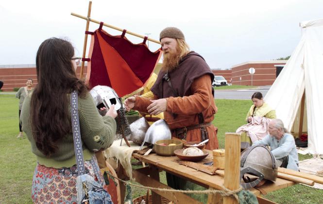 Dr. Reid Weber, a professor at the University of Central Oklahoma, speaks about helmets with Angel Fowler of Meeker. Weber is a member of the Glomesdal Vikings group which attends festivals like this to tell about Viking history and demonstrate fighting techniques. Also shown are Emily Cowen and Michal Carson. Also at the event were several arts and crafts vendors, as well as axe throwing and archery brought by Wretched Oaks of Noble. Natasha Dunagan, Countywide &amp;amp; Sun