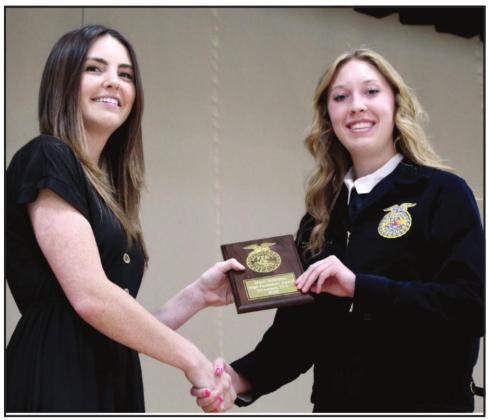 Tecumseh FFA Advisor McKenzie Hearn presents Marli Williams with the High Fundraiser Award.