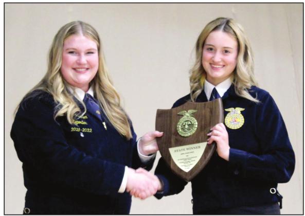 2021-22 Reporter Piper Goodson, left, presents Chloe Kelsey with the first-place State FFA Convention trophy for Prepared Public Speaking in the Animal Science Division during the Tecumseh FFA Banquet on May 12. Countywide &amp;amp; Sun/Natasha Dunagan