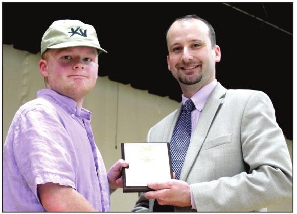 Tecumseh FFA Advisor Dodge Nichols presents the Most Improved Award to Nate Thompson.