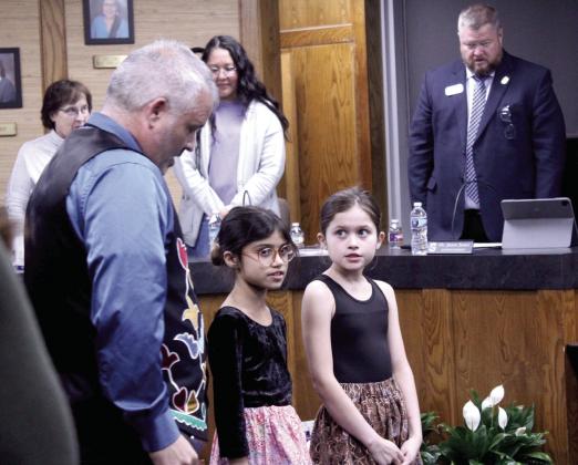 CPN Language Director Justin Neely leads a prayer in Potawatomi with his daughters Peyton and Prestynn Neely during the Jan. 12 Shawnee Board of Education meeting. Shown, in the background, are Board members Mandy Hillhouse and Kristen Wilson and Superintendent Dr. Jason James.