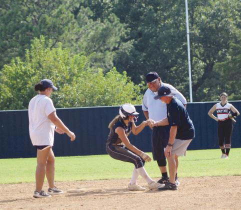 Asher sophomore Cadence Leba is helped up by Assistant Coach Scott Dubler, after stealing second base and hurting her foot while sliding. She went on to steal third and home.