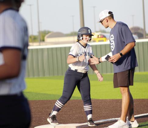 Shawnee sophomore Heaven Sams gets a secret handshake from Coach Nolan Looman after hitting a single during the McAlester game in the Shawnee Softball Tournament, held at FireLake Ball Fields on Aug. 24. The Lady Wolves lost 6-25.
