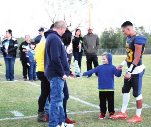 A young family member presents flowers on behalf of Bethel football senior Tyler McKinney during Senior Night, Oct. 28. Bethel honored 24 seniors in football, band, cheerleading, and cross country. Countywide &amp;amp; Sun/Natasha Dunagan