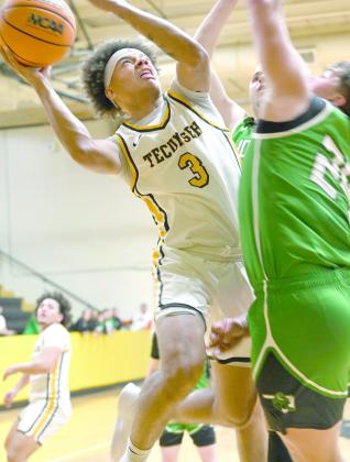 Tecumseh senior Jekhi Owens puts up a basket despite being double-teamed during the Jan. 13 home game against Jones. The Savages won 70-62. Earlier that night, the Lady Savages lost 35-63. Photo courtesy of Kenetta Lisenbee