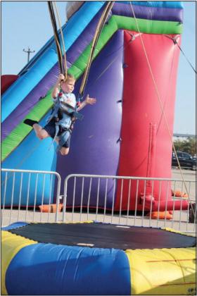Liam Hawkins, 5, of Tecumseh, jumps high on the bungee trampoline ride at the Pottawatomie County Free Fair on Sept. 9. Countywide &amp; Sun/Natasha Dunagan