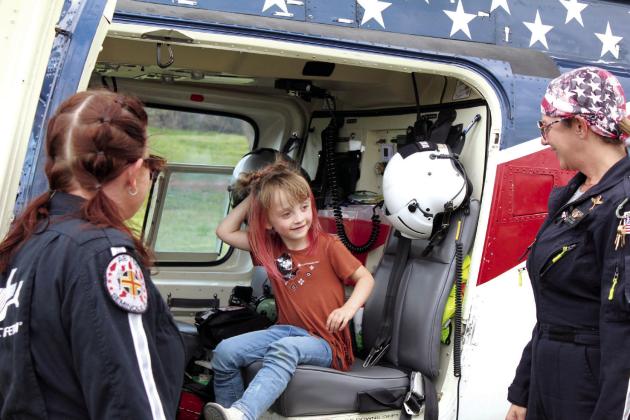 Savanna Garlington, 4, of Maud, talks with paramedic Britney Little, left, and nurse Amy Caudill, far right, while sitting in the Air Evac helicopter, out of Seminole, during the Touch A Truck and Beyond event, April 6, at the CPN Festival Grounds. In this third annual event organized by the Pottawatomie County Emergency Management,  there were 72 agencies and community partners in attendance, including fire departments, law enforcement agencies, large equipment operators, two helicopters and others.
