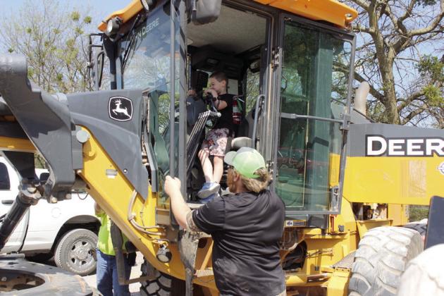 Madden Goodnight, 5, of Tecumseh, finds the horn button on a grader, as Steven Moore, of Pottawatomie County District 2 supervises during the Touch A Truck and Beyond event, April 6, at the CPN Festival Grounds. Moore's co-worker Tristen Newton was on the other side of the grader to assist. Countywide &amp; Sun/Natasha Dunagan