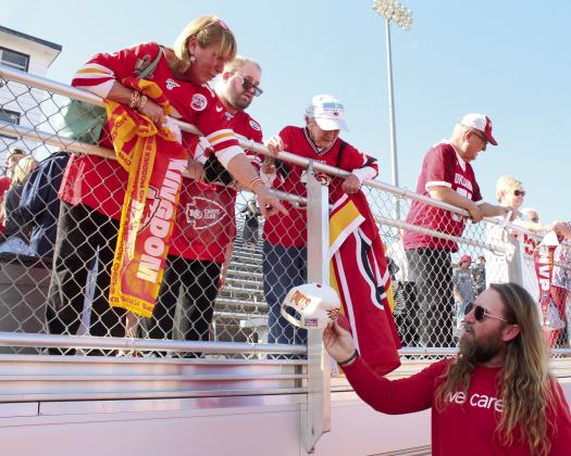 Verna Brooks, of Shawnee, hands Shawnee City Commissioner Travis Flood a hat which belonged to her father, Roy Slavin. Flood agreed to have Kansas City Chiefs Center Creed Humphrey sign one thing for Brooks and her mother, Julia Slavin, far left, during the Creed Humphrey Day Celebration on March 4. Brooks said her mother, age 90, has been a Chiefs fan for 60 years, and her parents had season tickets for 25 years. Her father was also a Citizen Potawatomi Nation tribal leader for 12 years.
