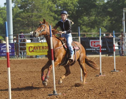 Jet Winn of Shawnee steers her horse around poles on the morning of July 8.