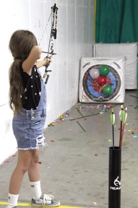 Charlie Jo Sartin, 8, of Earlsboro, practices shooting balloons at the Choctaw Archery Shoot during the Outdoor Network Expo at FireLake Arena on Aug. 9.