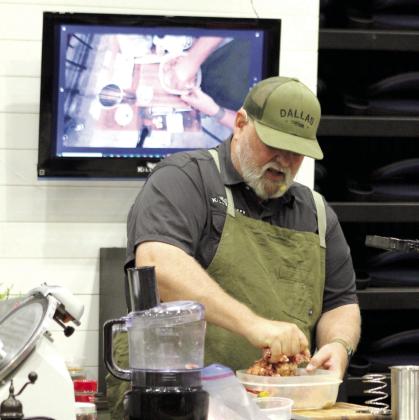 Jesse Morris, from Killer Chefs, mixes seasoning into some diced wild pork and demonstrates how to make it into a ham loaf during the Outdoor Network Expo at FireLake Arena on Aug. 9.